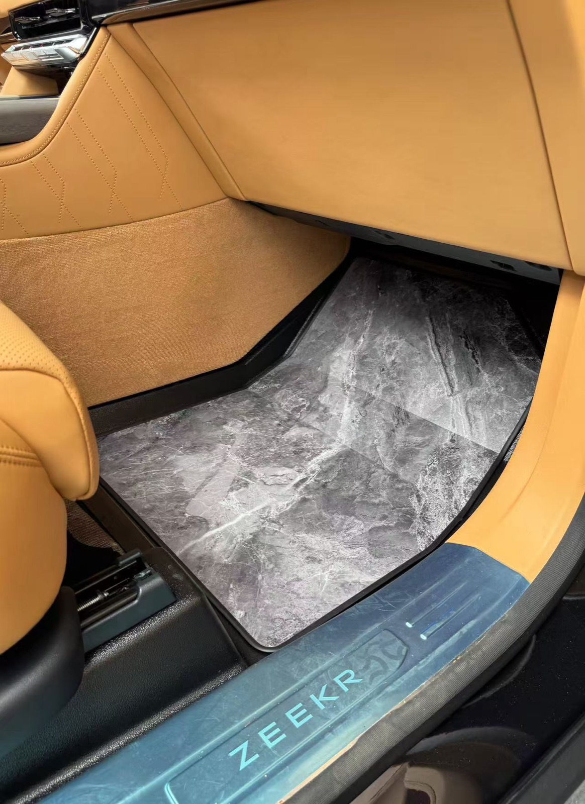 Driver footwell detail of a marble grey wooden floor in a flagship SUV
